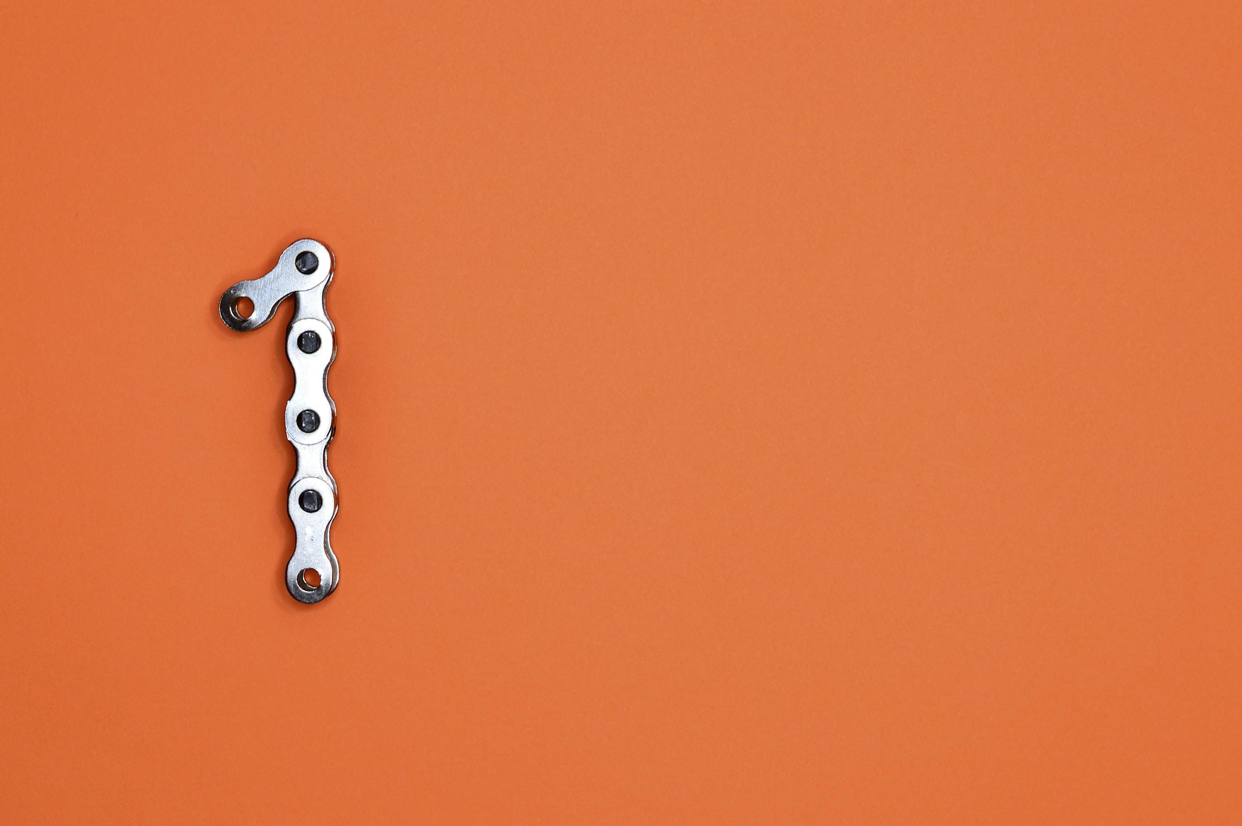 Youcanic Ucan-Ii Scanner Model Comparison Guide 1 Metal Chain Forming The Number One On An Orange Background, Ideal For Design Concepts.