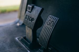 Close-Up Photograph Of Go And Stop Pedals In A Vehicle, Highlighting Texture.